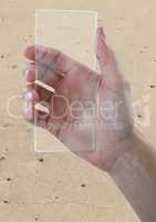 Hand with glass device against sand