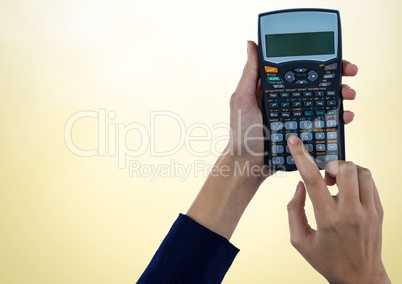 Hands with calculator against yellow background