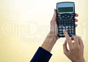 Hands with calculator against yellow background