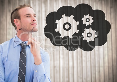 Business man thinking against blurry wood panel and cloud with gear graphic