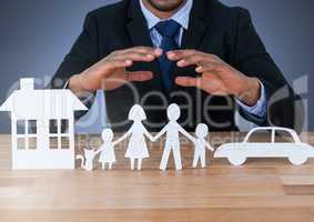 Cut out house family and car under protective hands