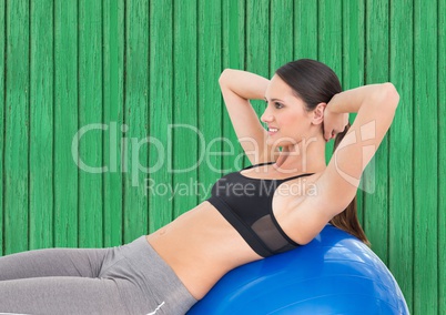 fitness woman with big ball with green wood background