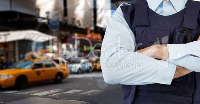 Policeman crossing his arms in a street in front of a yellow taxi