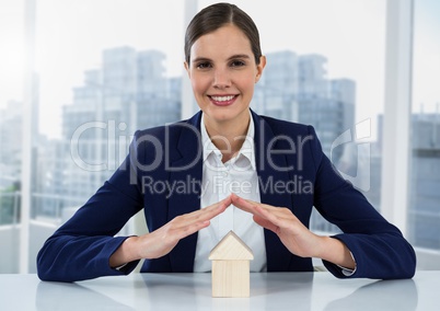 House under womans hands by window and city