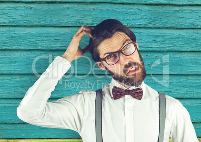hipster scratching his head with light blue wood background