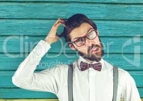 hipster scratching his head with light blue wood background