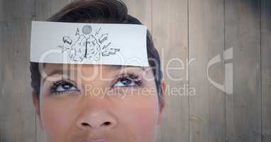 Close up of woman with card on head showing brain doodle against wood panel