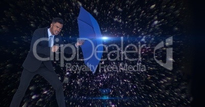 Digital composite image of businessman holding blue umbrella amidst asteroids