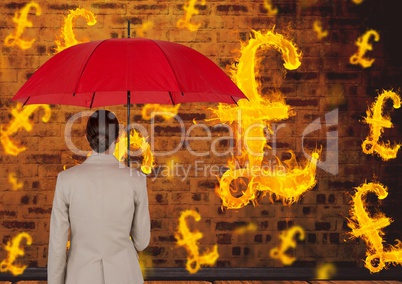 Digital composite image of businesswoman holding red umbrella looking at burning symbol of pounds