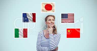 Thoughtful smiling woman standing by flags against blue background