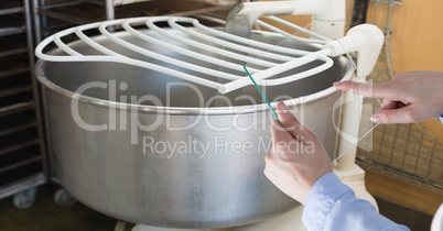 Hand taking picture of utensil with transparent device at bakery