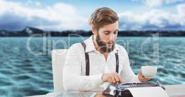 Creative businessman working on typewriter while having cup of tea