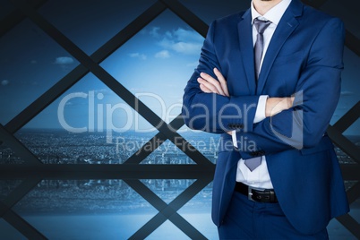 Business man with crossed arms against cityscape background