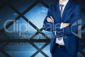 Business man with crossed arms against cityscape background