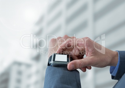 Businessman holding watch against buildings