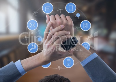 Businessman holding watch with apps icons in large room