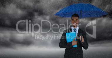 Business man with umbrella and blue book against storm clouds with rain