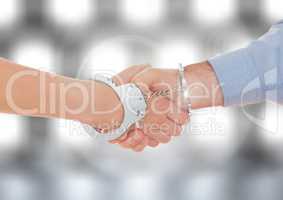 Hands shaking in hand cuffs with sparkling light bokeh background