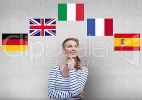 main language flags around young happy woman thinking.