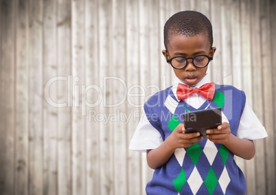 Boy in vest and bowtie with calculator against blurry wood panel