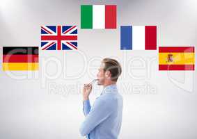 main language flags around young businessman thinking