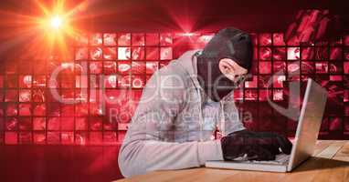 Housebreaker typing on laptop in front of red digital screen