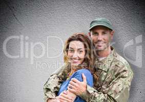 soldier and wife smiling. concrete wall