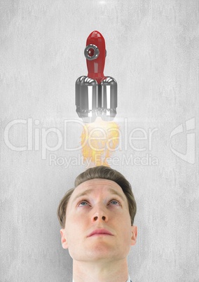 Digital composite image of man looking up at rocket launch