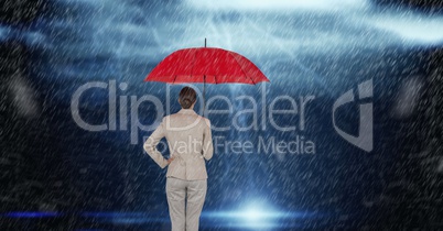 Rear view of businesswoman holding red umbrella standing in rain