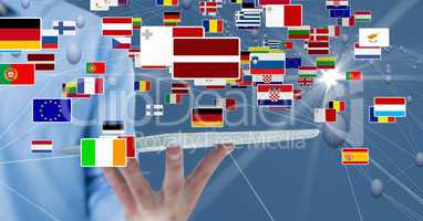 Midsection of businessman holding digital tablet with various flags and connecting dots