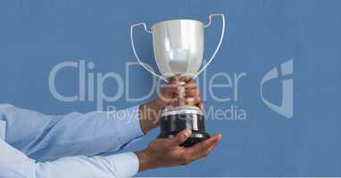 Hands holding trophy against blue background