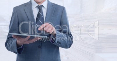 Businessman holding tablet in bright warehouse