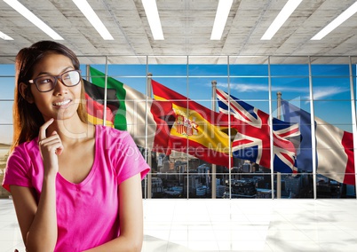 main language flags behind the window. Young happy woman in the office
