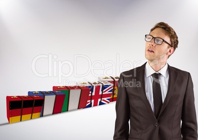 main language flags suitcases behind young businessman thinking