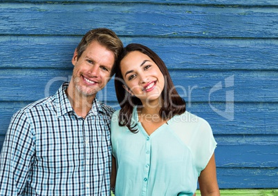 couple smiling with blue wood background