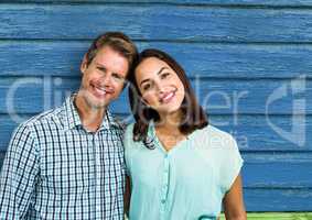 couple smiling with blue wood background
