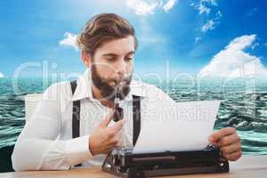 Hipster man with a pipe reflecting on his typewriter in front of sea background