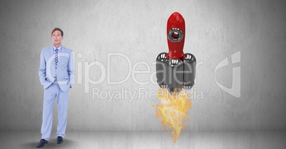 Digital composite image of businessman standing by rocket launch against gray background
