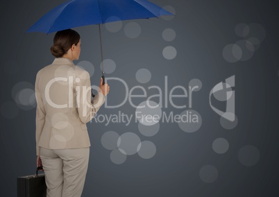 Back of business woman with umbrella and briefcase against grey background and bokeh