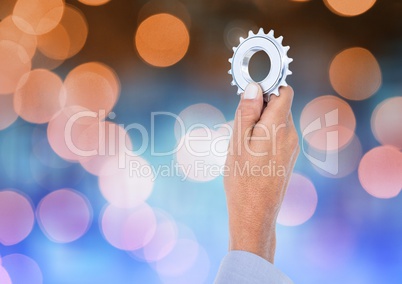 Hand holding settings cog igon with sparkling light bokeh background