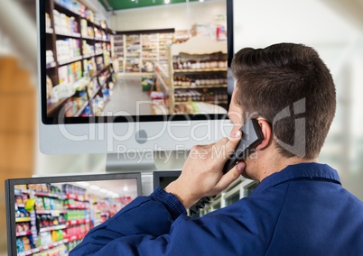 security guar phoning in front of the security screens.