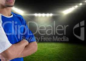soccer player with his hands folded and with blue t-shirt in the field at night with lights