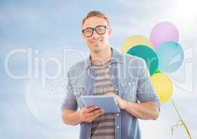 Man with tablet against sunny sky and balloons with flare