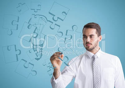 Business man drawing jigsaw doodle against blue background