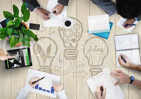 Overhead of business team with cream wood panel and lightbulb graphic