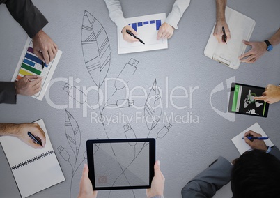 Overhead of business team writing on grey surface with leaf doodle