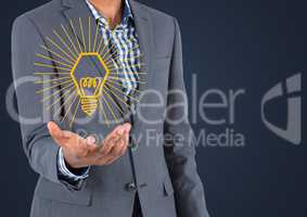 Business man mid section with yellow lightbulb graphic in hand against navy background
