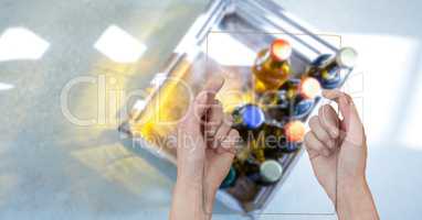 Directly above shot of hands taking picture of alcohol bottles through transparent device