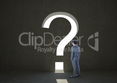 Rear view of businessman standing while looking at question mark sign