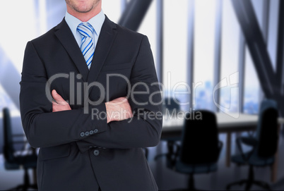 businessman crosses his arms against office background